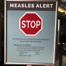 file-20210804-13-g7e0u2 Notice for Measles Alert. stop sign. Attention all patients and visitors for your protection please put on a mask if you have symptoms